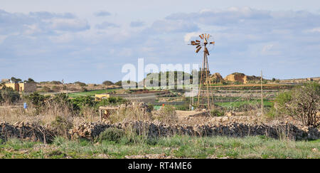 Vista panoramica su una bella wild west paesaggio con muri in pietra, cottage e la rottura di un mulino a vento a Dingli, Malta su un soleggiato, Dingli. Malta. Europa Foto Stock