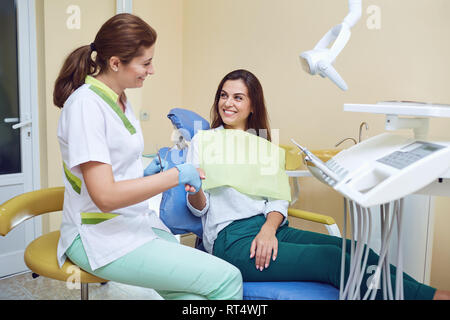 Dentista scuote le mani con una donna client in una clinica dentale Foto Stock