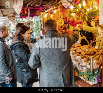 COLMAR, Francia - Nov 23, 2014: giovane acquisto di caramelle al mercato di Natale di stallo nella città francese - cibo tradizionale e doni Foto Stock