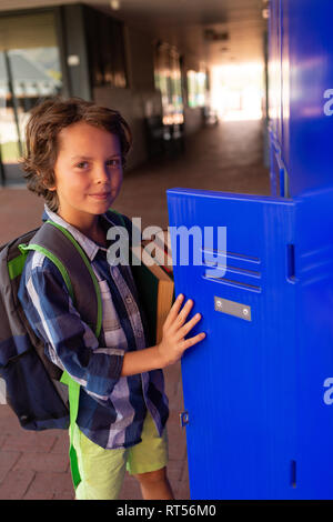 Scolaro apertura del gavone in spogliatoio Foto Stock