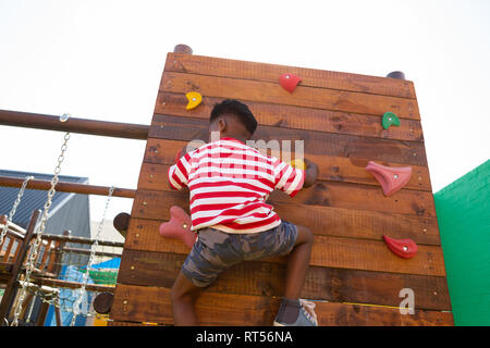 Scolaro salendo una parete nella scuola parco giochi Foto Stock