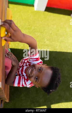 Scolaro salendo una parete nella scuola parco giochi Foto Stock
