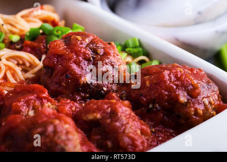 In casa polpette di carne di manzo con gli spaghetti in salsa marinara servita in una teglia su tavola in legno rustico e tradizionale cucina italiana, vicino, selezione Foto Stock