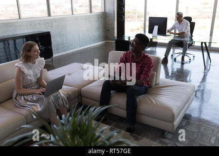 Maschio e femmina dirigenti interagire gli uni con gli altri in ufficio Foto Stock