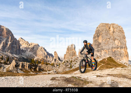 L'Italia, Cortina d'Ampezzo, uomo escursioni in bicicletta con la mountain bike nelle Dolomiti Foto Stock