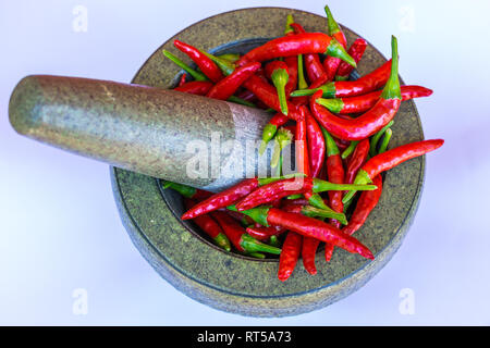 Birds Eye peperoncini rossi in un mortaio e pestello Foto Stock