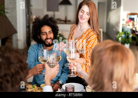Gli amici a bere vino a una cena, bicchieri tintinnanti