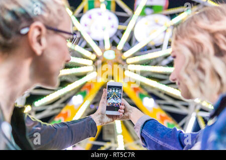 Madre e figlia di prendere foto della grande ruota al fair Foto Stock