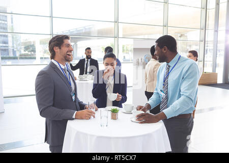 La gente di affari interagire gli uni con gli altri al tavolo durante un seminario Foto Stock