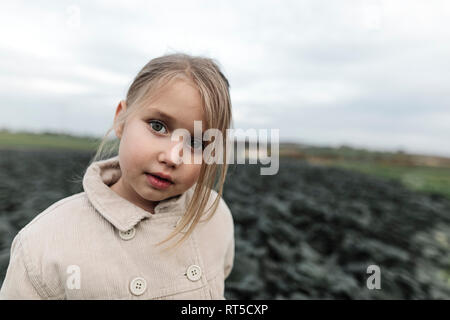 Ritratto di una ragazza in piedi su un campo di cavolo cappuccio Foto Stock