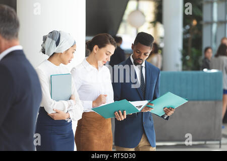 Diverse persone di affari che cercano e discutere sui file Foto Stock