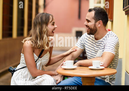 Spagna, Andalusia, Malaga, felice coppia avente un caffè in un vicolo Foto Stock