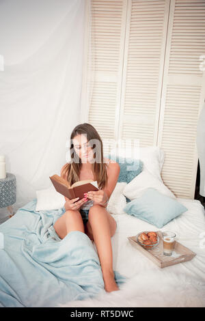 Giovane donna con un libro nelle sue mani Foto Stock