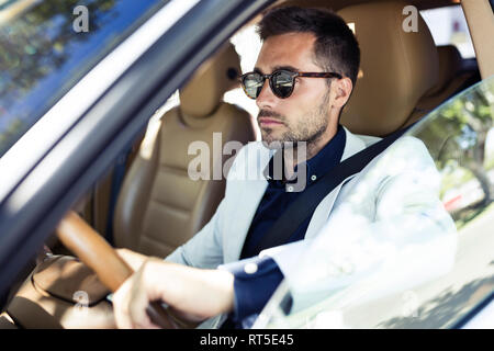 Successo imprenditore giovane guida nella sua auto Foto Stock