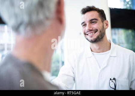 Uomo in medico sorridente globale alla grey-haired man Foto Stock