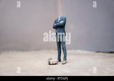 Imprenditore Headless figurina in piedi sul cemento Foto Stock