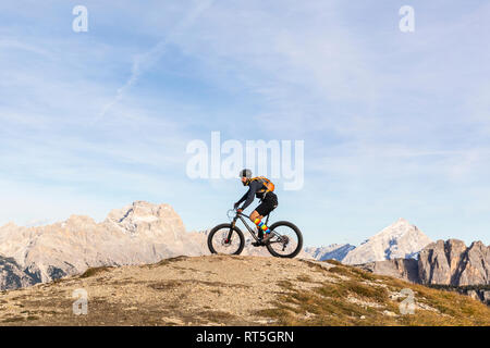 L'Italia, Cortina d'Ampezzo, uomo escursioni in bicicletta con la mountain bike nelle Dolomiti Foto Stock