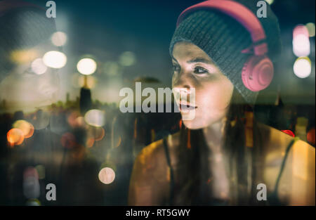 Ritratto di giovane donna con le cuffie al crepuscolo Foto Stock