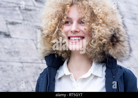 Ritratto di ridere donna bionda con boccoli indossando la cappa pelliccia Foto Stock