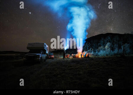 Il Cile, Tierra del Fuego, Lago Blanco, falò e persone in camper sotto il cielo stellato di notte Foto Stock