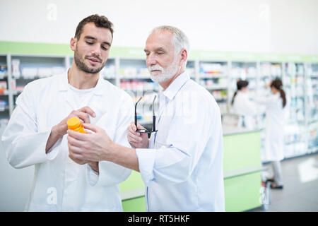Due farmacisti esame di medicine in farmacia Foto Stock