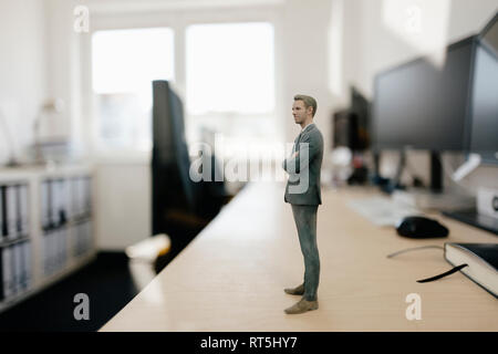 Imprenditore figurina in piedi sulla scrivania in ufficio moderno Foto Stock