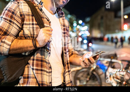 UK, Londra, close-up dell'uomo il pendolarismo di notte nella città e utilizzando il suo telefono Foto Stock