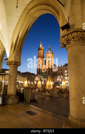 La Polonia, Cracovia, la città di notte, vista verso la chiesa di Santa Maria dal porticato del tessuto Hall nella Città Vecchia Foto Stock