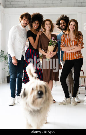 Foto di gruppo con un cane, di amici, celebrando ghe compleanno og una giovane donna Foto Stock