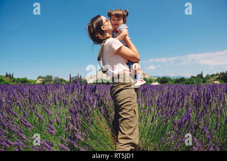 Francia, Grignan, madre baciare piccola figlia in campo di lavanda Foto Stock