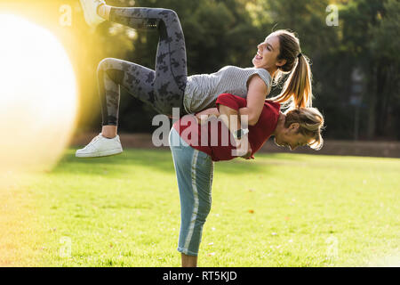 Nonna nipote di sollevamento sulla sua schiena, divertirsi in un parco Foto Stock