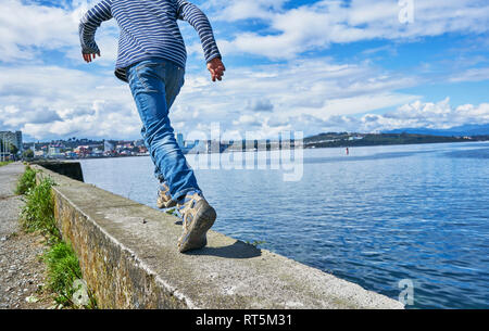 Il Cile, Puerto Montt boy in esecuzione sul quay parete presso il porto Foto Stock