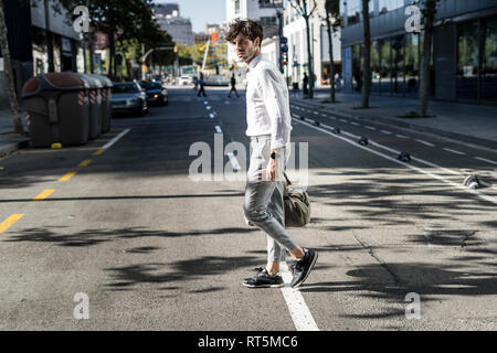 Giovane uomo nella città in viaggio attraversando via Foto Stock