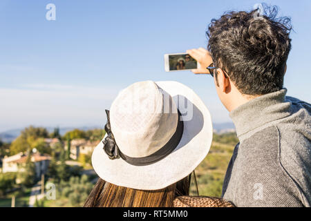 L'Italia, Toscana, Siena, coppia giovane prendendo un selfie presso una cantina Foto Stock