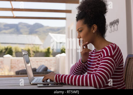 Donna che utilizza portatile a casa Foto Stock