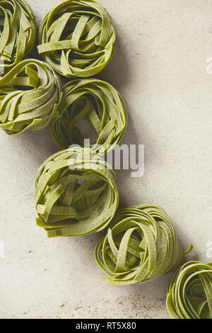 Materie asciugare gli spinaci tagliatelle di pasta sulla tabella grigia, vista dall'alto Foto Stock