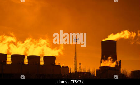 Industrial Estate al tramonto che mostra la torre di raffreddamento e camini presso la BASF produzione chimica sito nel porto di Anversa, Belgio Foto Stock