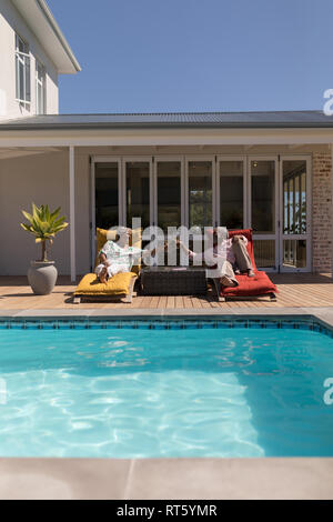 Coppia senior tostare bicchieri di cocktail nel cortile di casa Foto Stock