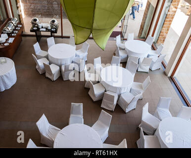 Vista dall'alto verso il basso di un vuoto ristorante con tavoli e sedie disposti in una configurazione circolare, per ospitare un buffet. Hyderabad, Telangana, India. Foto Stock