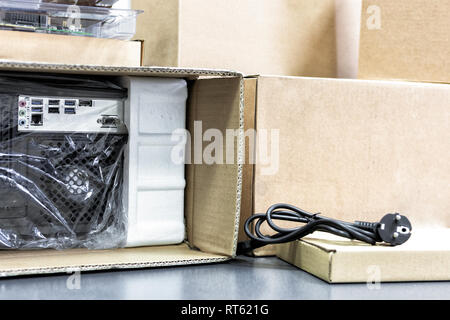 Disimballaggio black personal computer, vista posteriore, cellophane  imballaggio. Molte scatole per desktop componenti hardware Foto stock -  Alamy