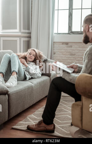 La condivisione di pensieri. Barbuto terapista privato ascoltando la bella ragazza adolescente condividere il suo pensiero Foto Stock