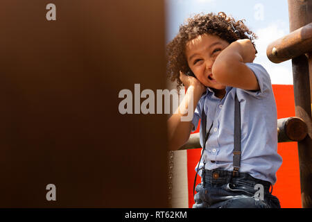Schoolgirl ascoltando musica sulle cuffie nella scuola parco giochi Foto Stock