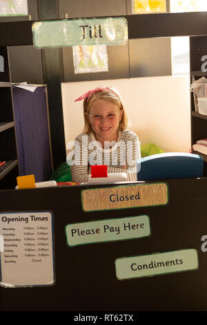 Schoolgirl fingendo di essere un dirigente di bill counter Foto Stock