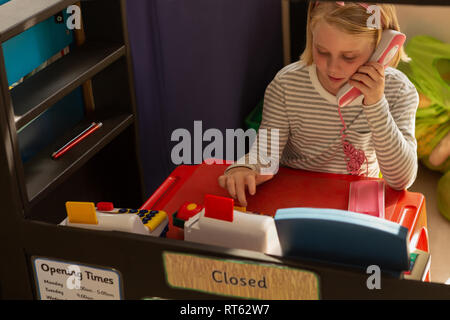 Schoolgirl fingendo di essere un dirigente di bill counter Foto Stock