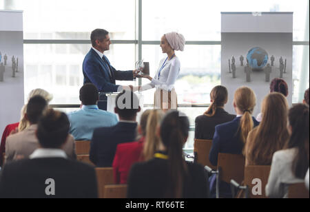 Imprenditrice riceve un premio dal proprietario in un seminario di business Foto Stock