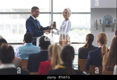 Imprenditrice riceve un premio dal proprietario in un seminario di business Foto Stock