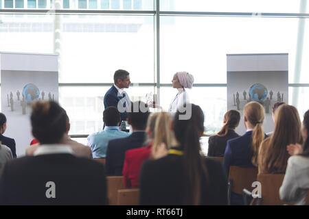 Imprenditrice riceve un premio dal proprietario in un seminario di business Foto Stock