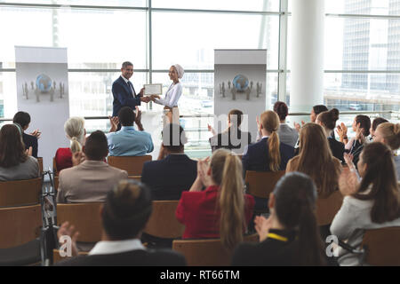 Imprenditrice riceve un premio dal proprietario in un seminario di business Foto Stock