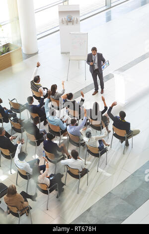 Gruppo di diverse persone di affari ad alzare la mano per porre domande ai proprietari a una conferenza. Foto Stock