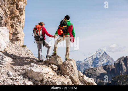 L'Italia, Cortina d'Ampezzo, giovane con corda e arrampicata attrezzature per mano e cercando di visualizzare Foto Stock